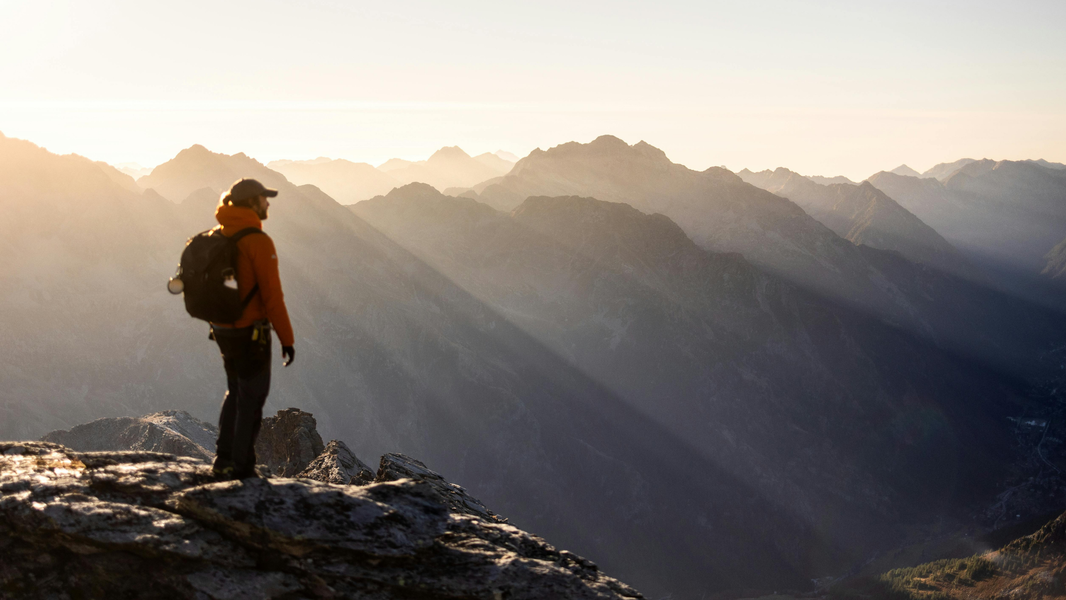 Man silhouetted with backpack at coastal cliff at sunset — NO&YO Guatemala adventure travel — Guatemala Wasn't on the Plan