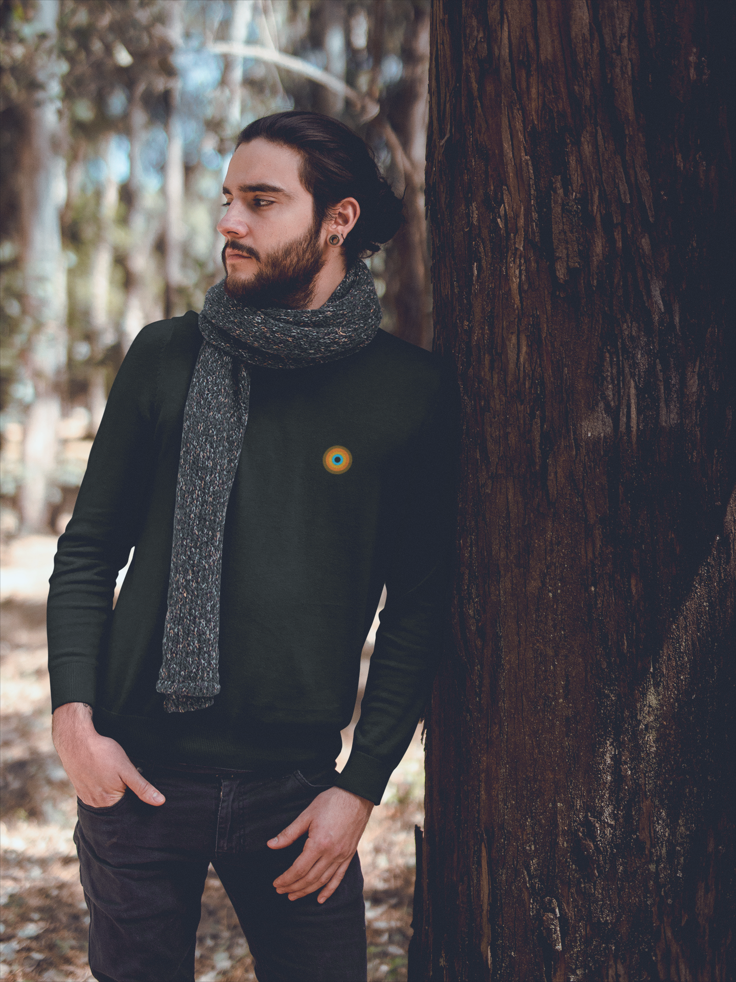 Model in NO&YO Heather Black crewneck sweatshirt with scarf, standing in woods, premium adventure lifestyle clothing.