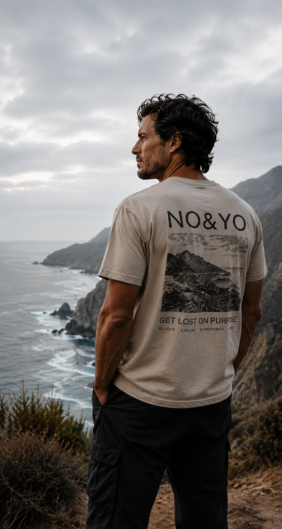 an wearing NO&YO adventure apparel overlooking a rugged coastline.