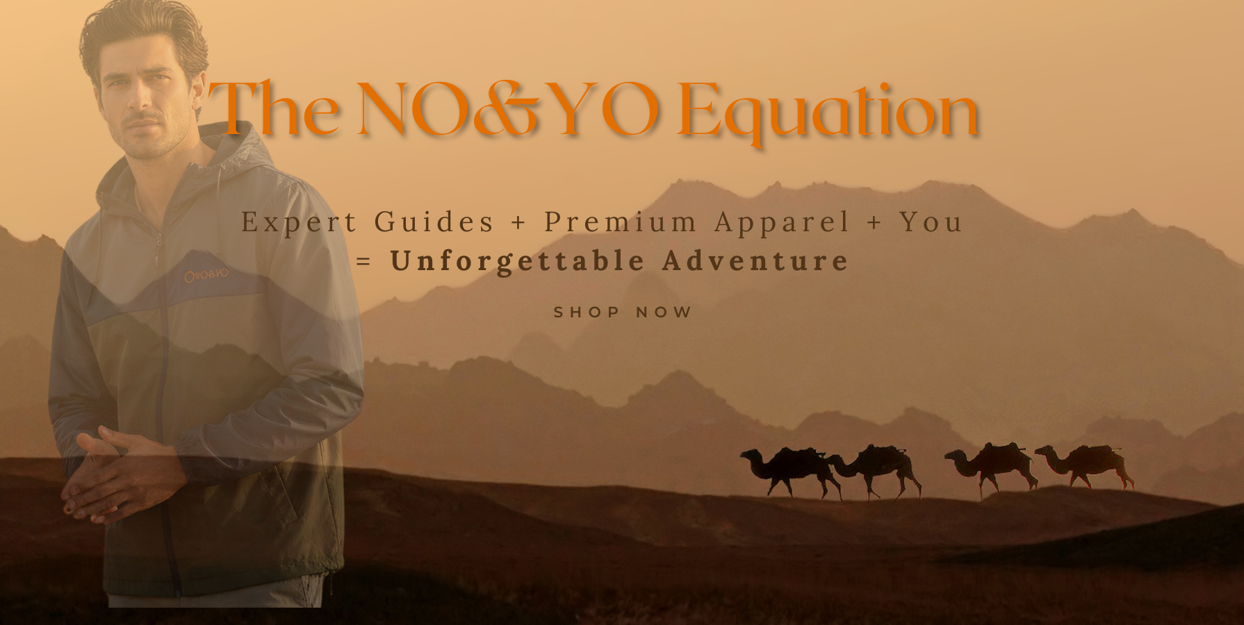 Male model wearing NO&YO premium outdoor jacket in a desert landscape with mountains and camel caravan, representing luxury adventure and exploration.