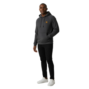 Man wearing a dark gray hoodie with a small logo, black pants, and white sneakers on a light gray background