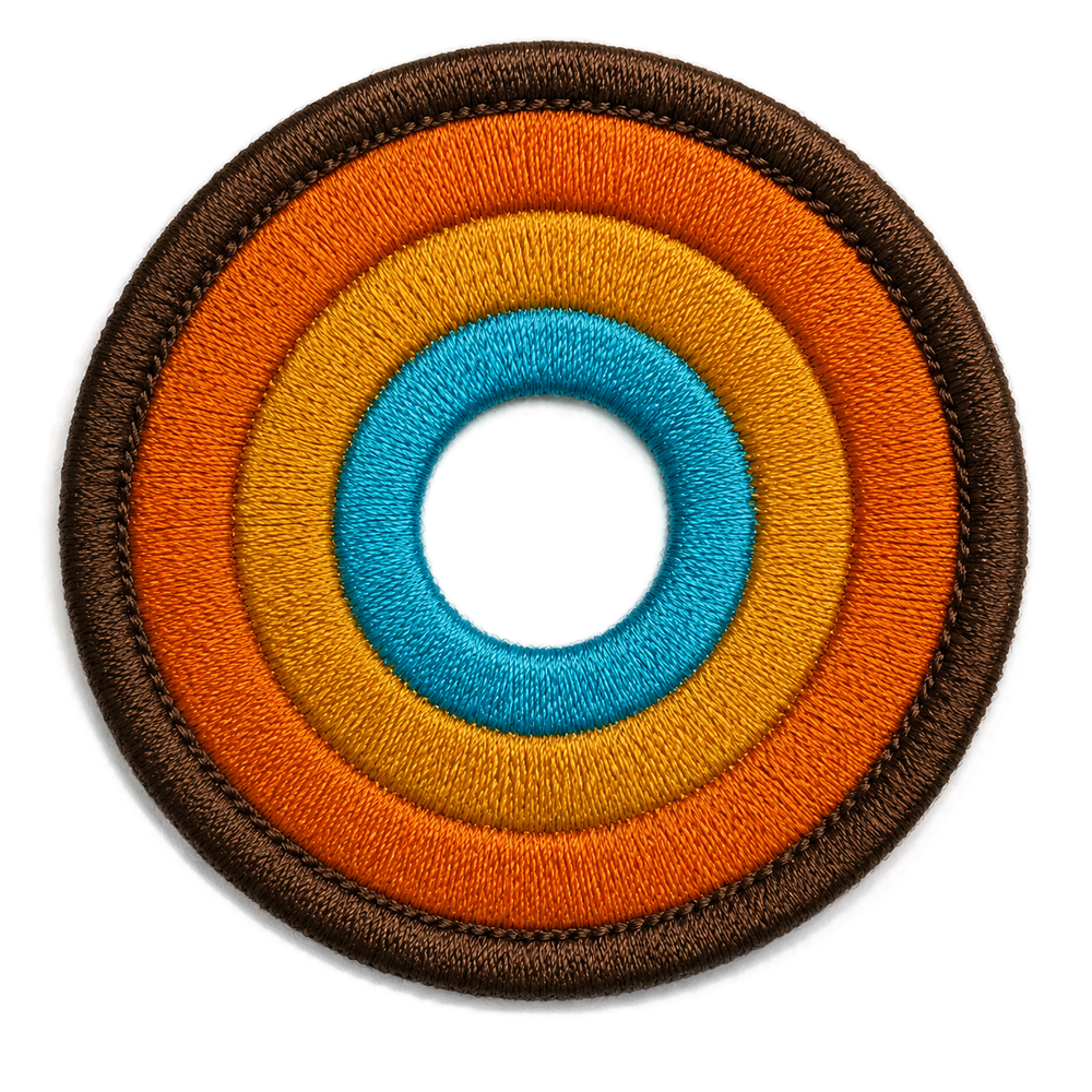 NO&YO embroidered sunset badge logo featuring concentric adventure-inspired rings in brown, orange, gold, and blue.